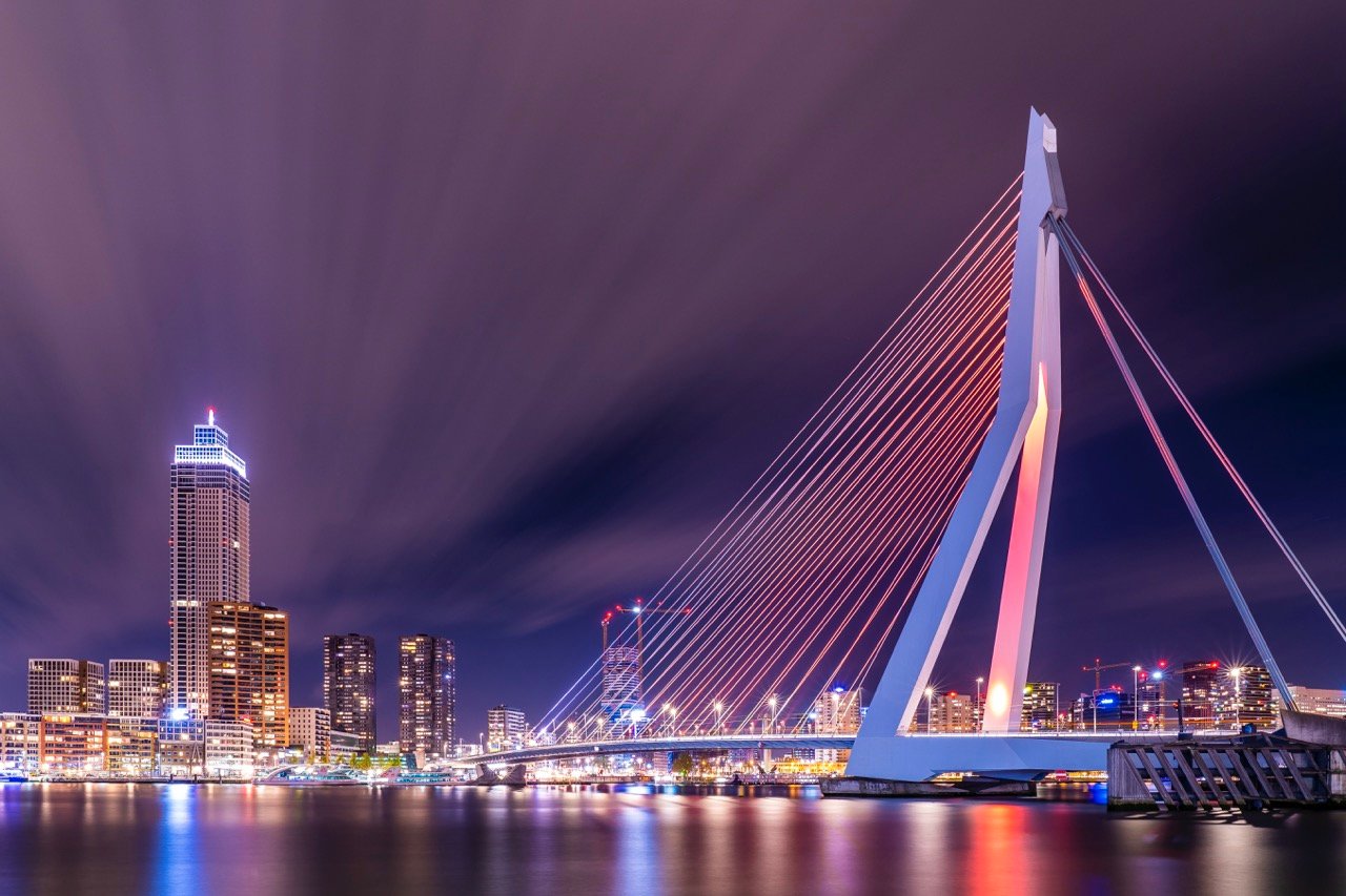 De verlichte Erasmusbrug en de skyline van Rotterdam